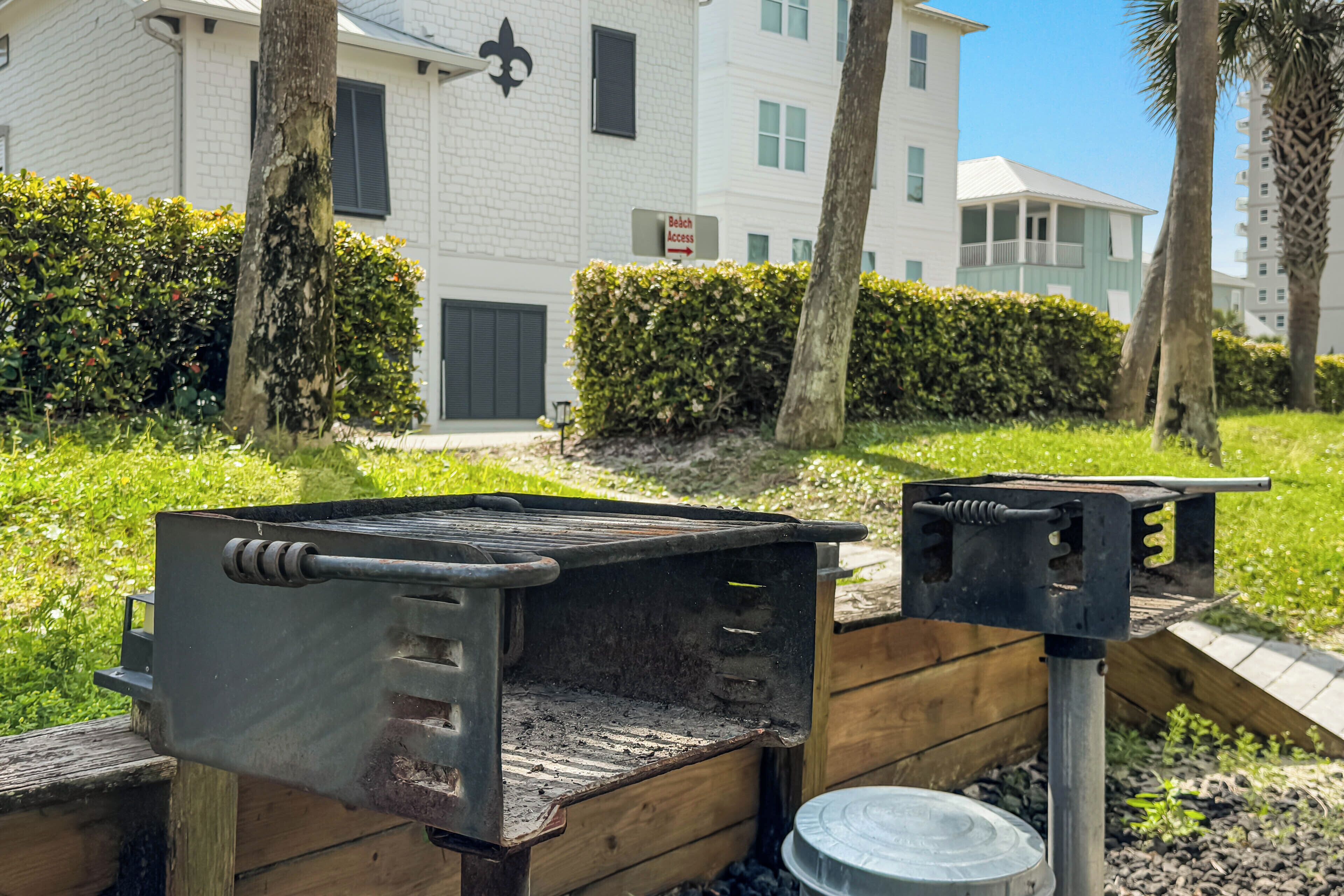 Una parrilla portátil con rejilla metálica, asa de metal y estructura de soporte metálica.