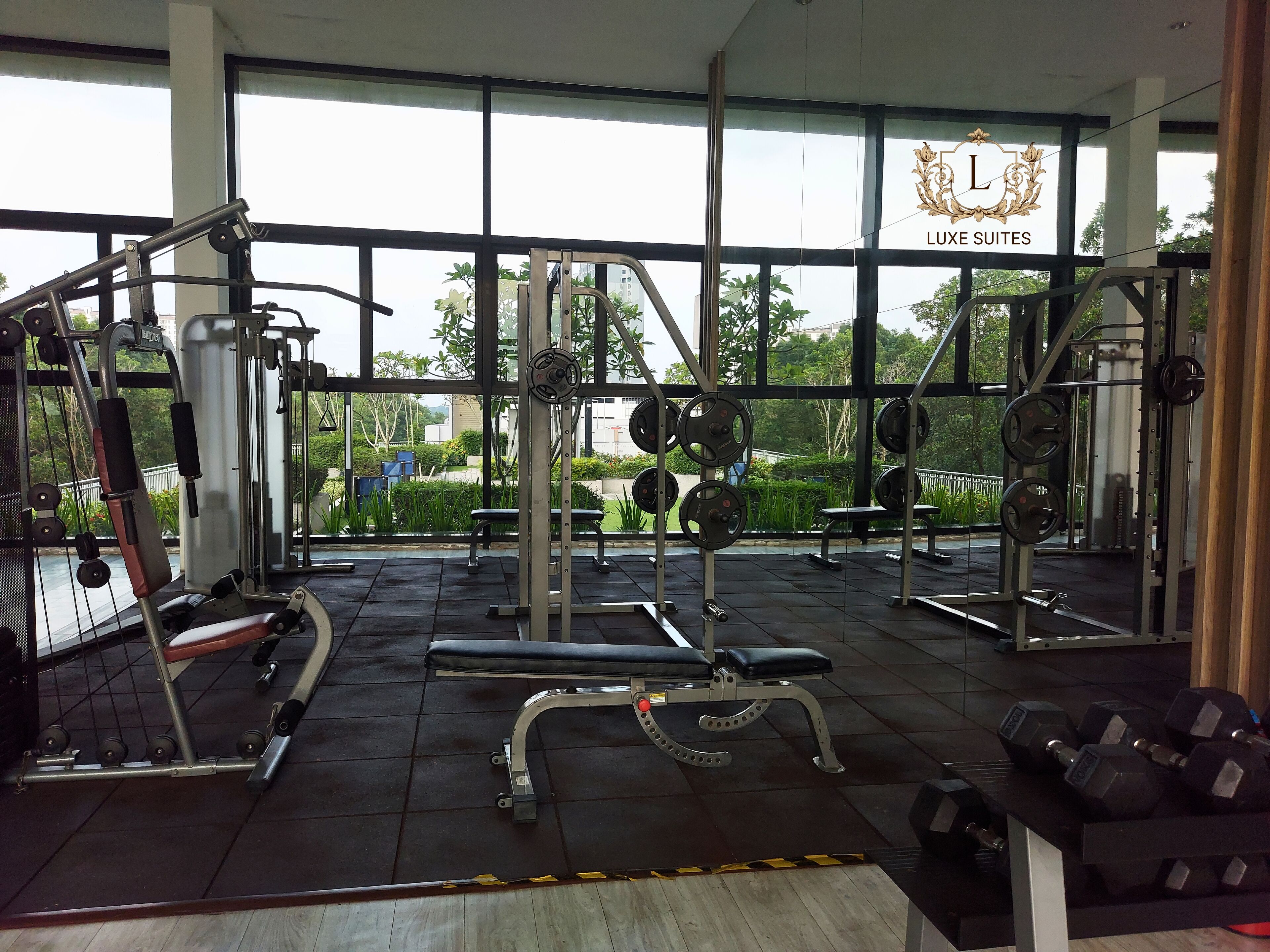 A gym with various exercise equipment, benches, and weight racks.