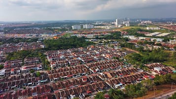 A residential area with uniform housing, roads, and distant high-rise buildings.
