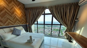 A bedroom with a large window, a bed with white linens, and a view of a cityscape. - Luxe Suites at Skyloft (Johor Bahru)
