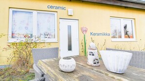 Un edificio amarillo con las palabras "ceramic" y "Keramiikka" en la fachada, lo que sugiere una tienda o estudio de cerámica.