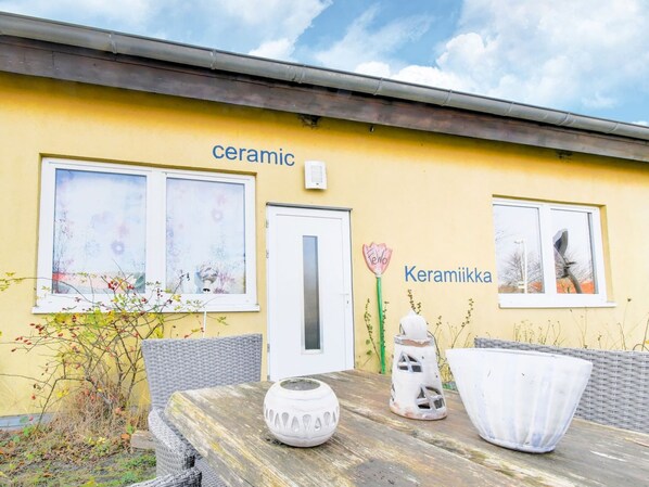 Un bâtiment jaune dont la façade porte les mots « céramique » et « Keramiikka », ce qui laisse supposer qu’il s’agit d’un magasin ou d’un atelier de céramique.