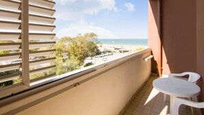 A balcony with a view of the beach, a table, and chairs. - Coastal Retreat in Riccione (Riccione)