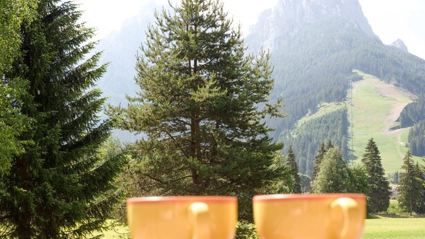Two yellow cups on a wooden tray with a scenic mountain view in the background. - Spacious Chalet with Garden near Ski Area in Tyrol (San Giovanni di Fassa)