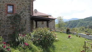 Un edificio in pietra con tetto in tegole, una piccola finestra e un'antenna parabolica.