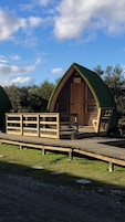 Una estructura de madera con techo verde, una terraza de madera y una puerta con la etiqueta 'D1'.