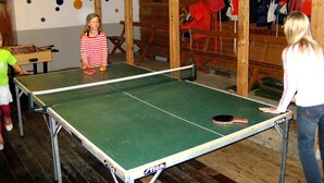 Ein Tischtennischraum mit Holzwänden und einem Kicker.