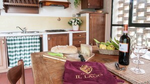 A kitchen with wooden cabinets, a gas stove, a sink, and a window with a view of a brick wall. - Peaceful Farmhouse in Dicomano (Dicomano)
