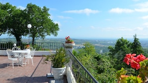 A terrace with a table and chairs, a railing, and potted plants. - Cottage in Montefiore Near Forest and Beach (Montefiore Conca)
