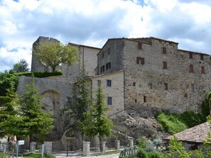 Un edificio histórico de piedra con múltiples ventanas y una torre.