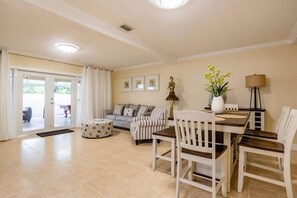 A spacious living area with a dining table, chairs, a sofa, and a coffee table. - Miami 305 Home. (Miami)