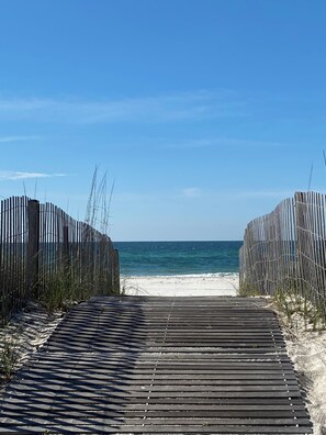 A wooden boardwalk leading to a sandy beach with a clear blue sky. - Beachfront Condo in Gulf Shores - Steps to the Beach - Walk to Dining - Sleeps 6 (Gulf Shores)