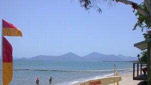 A beach with a lifeguard stand and a surfboard labeled "LIFEGUARD" on the sand. - Tropical Beachside Home - Pool, Wifi (Holloways Beach)