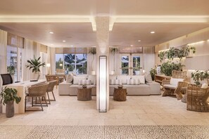 A spacious living area with a sofa, coffee table, and chairs, a desk with a laptop, and large windows with curtains. - Alaia Belize, Autograph Collection  (San Pedro)