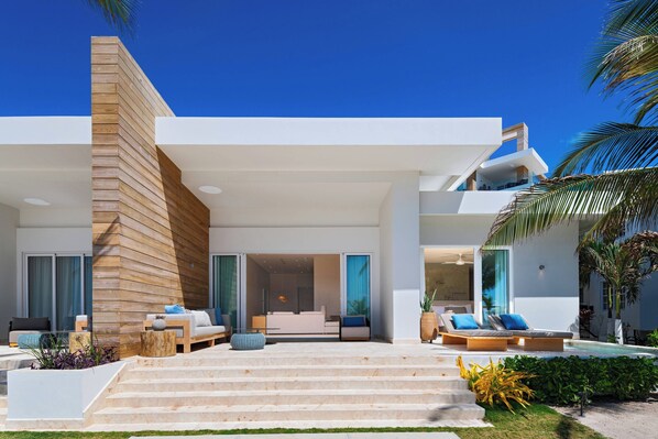 A modern house with a staircase leading to a balcony, a pool area, and a well-maintained garden. - Alaia Belize, Autograph Collection  (San Pedro)