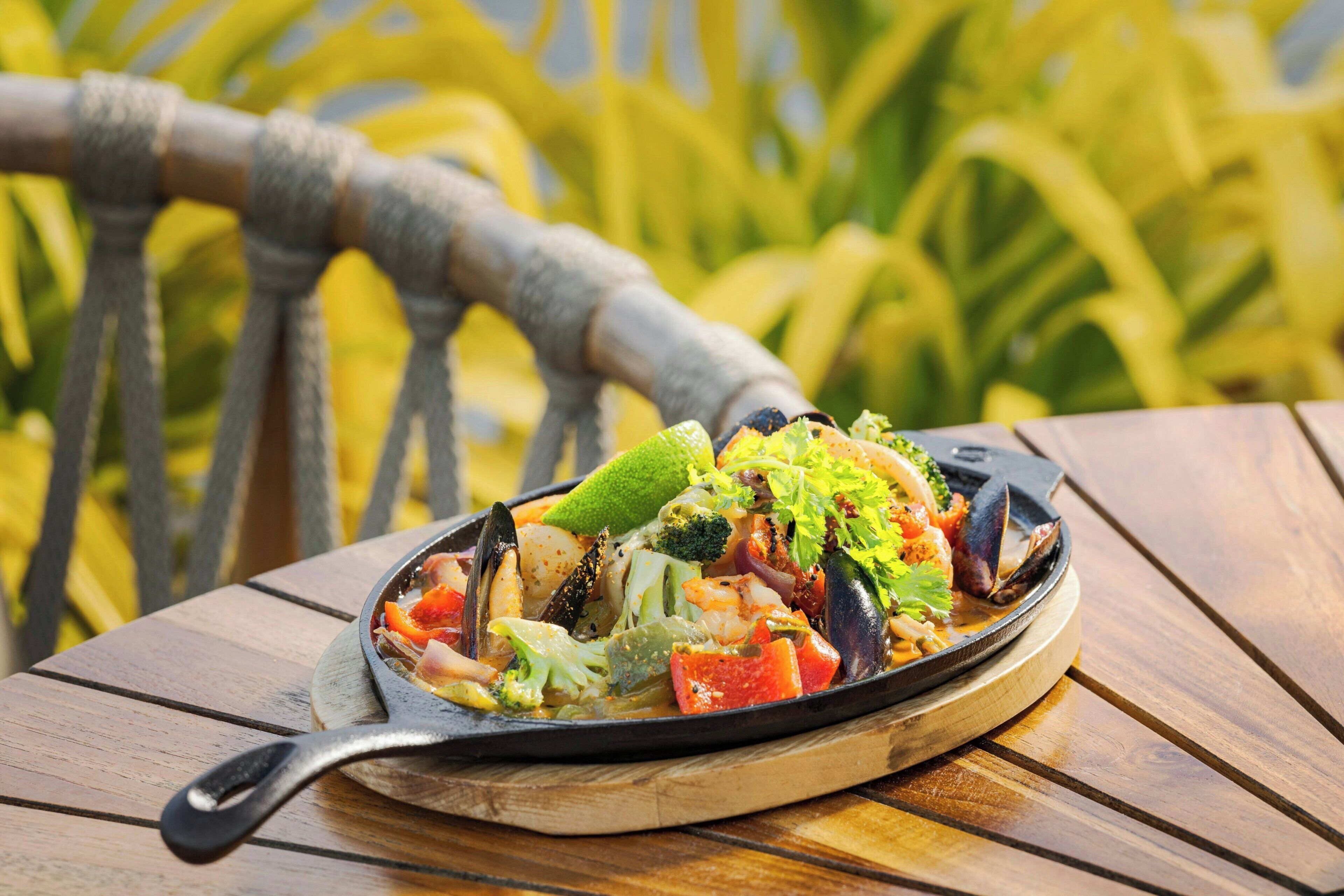 A seafood dish on a wooden table outdoors.