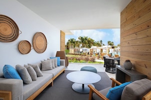 A modern lounge area with a sofa, round table, and wicker wall decor.