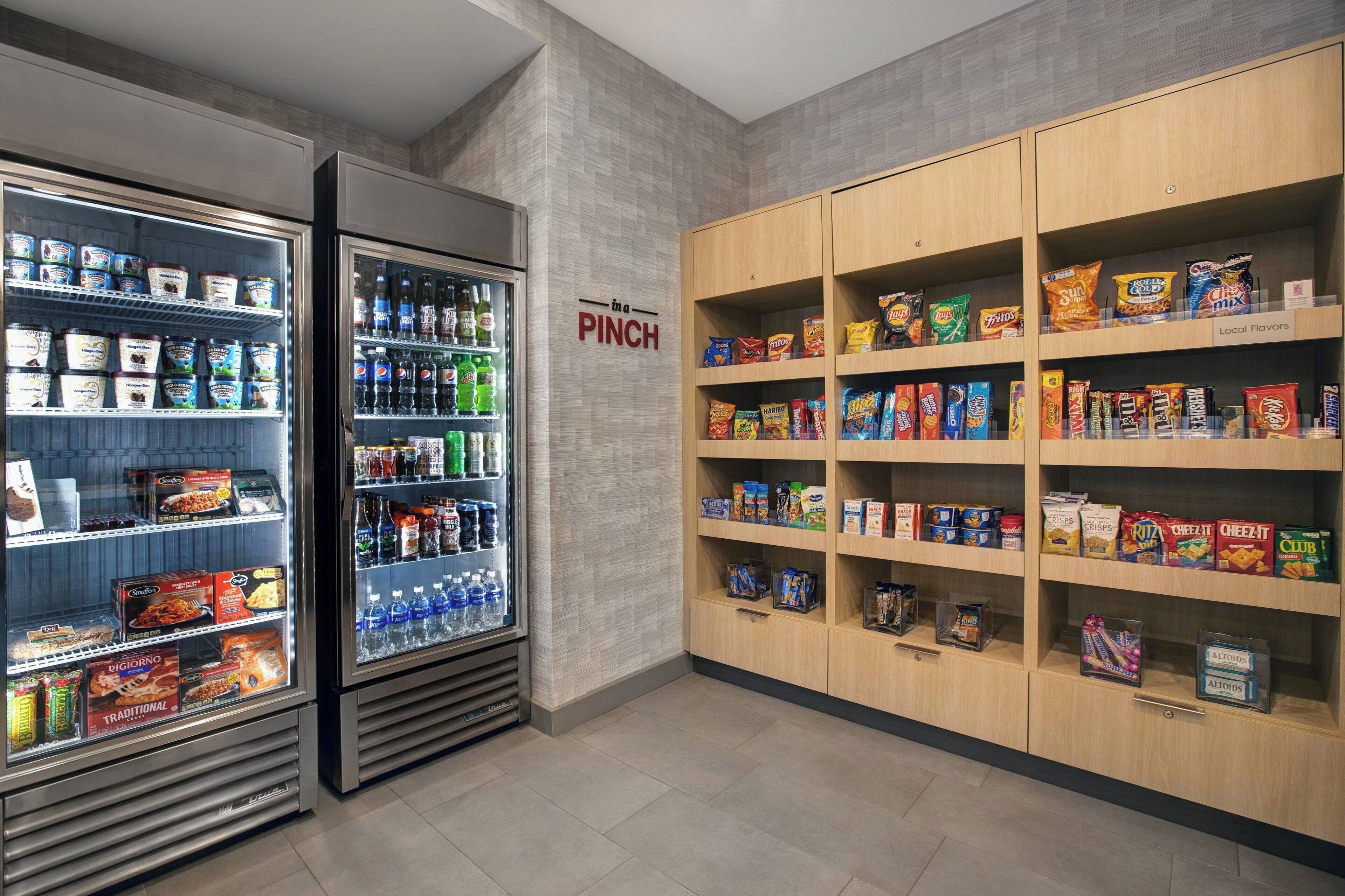 A snack and beverage section with refrigerated drinks and shelves stocked with snacks and local flavors.