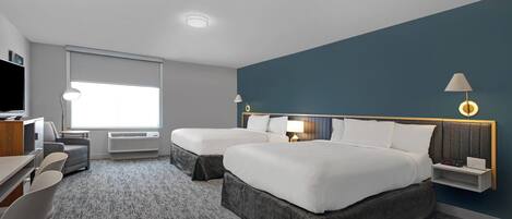 A modern hotel room with two beds, a desk, a chair, and a large window.