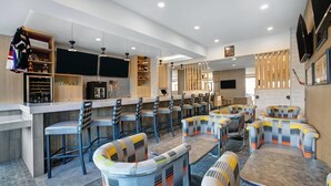 Un restaurante moderno con taburetes altos, cabinas y una zona de bar, con diversas opciones de asientos.