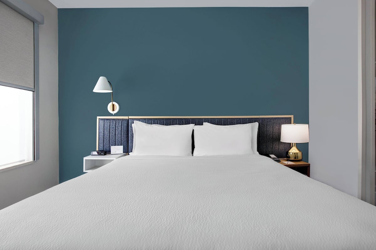Escritorio, cortinas blackout y tabla de planchar con plancha