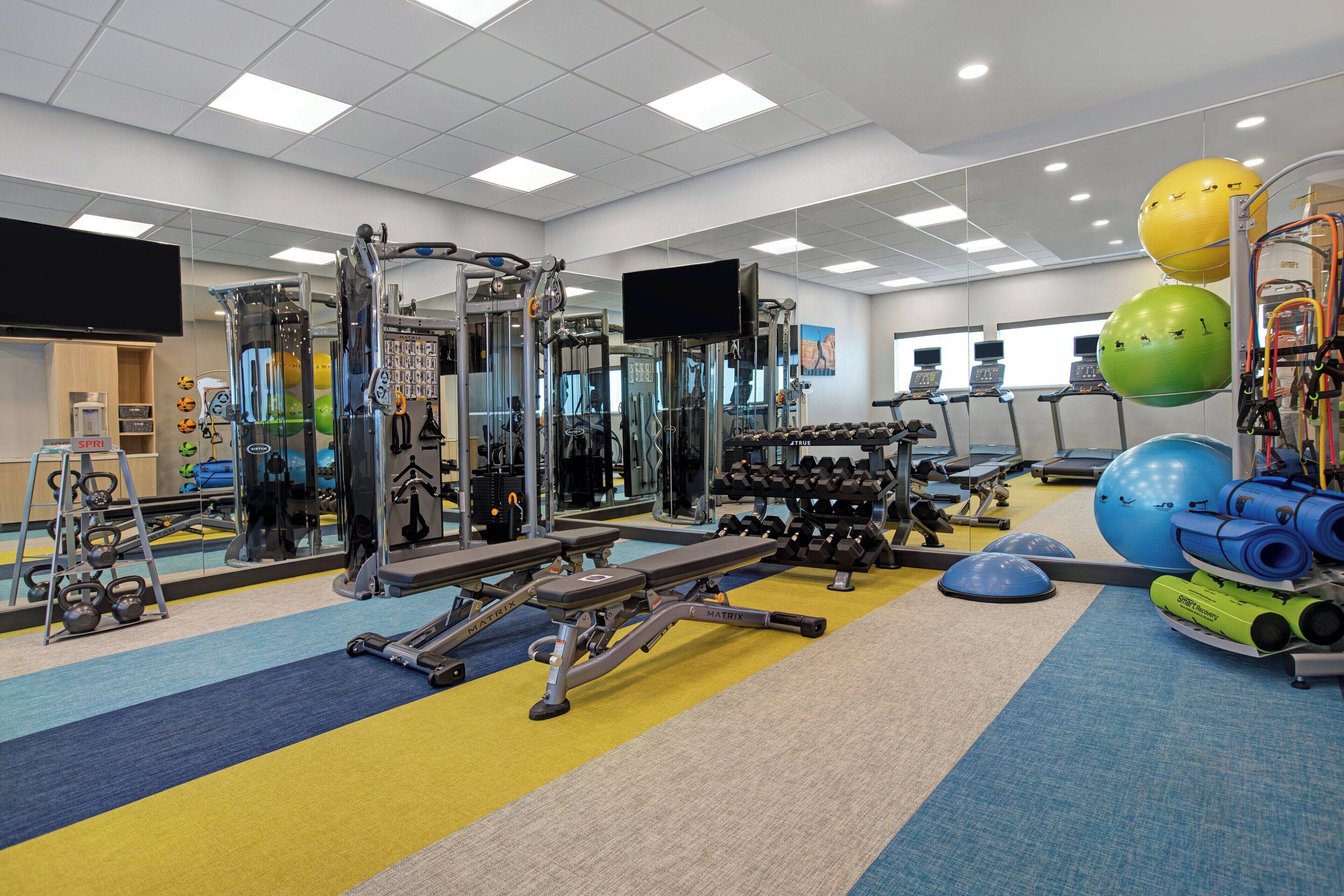 A gym with various exercise equipment, treadmills, and weight machines.