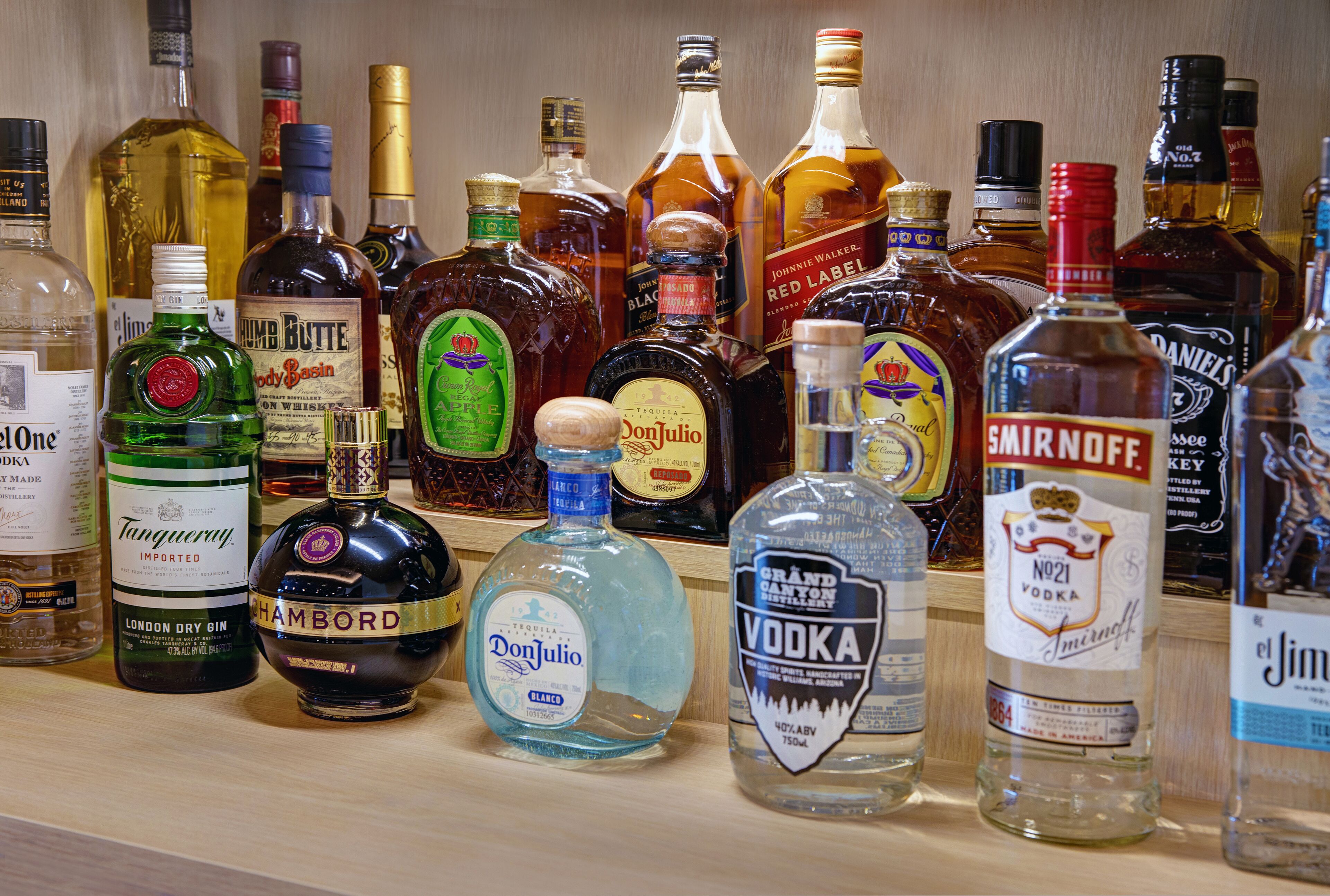 Diversas garrafas de bebidas alcoólicas numa prateleira.