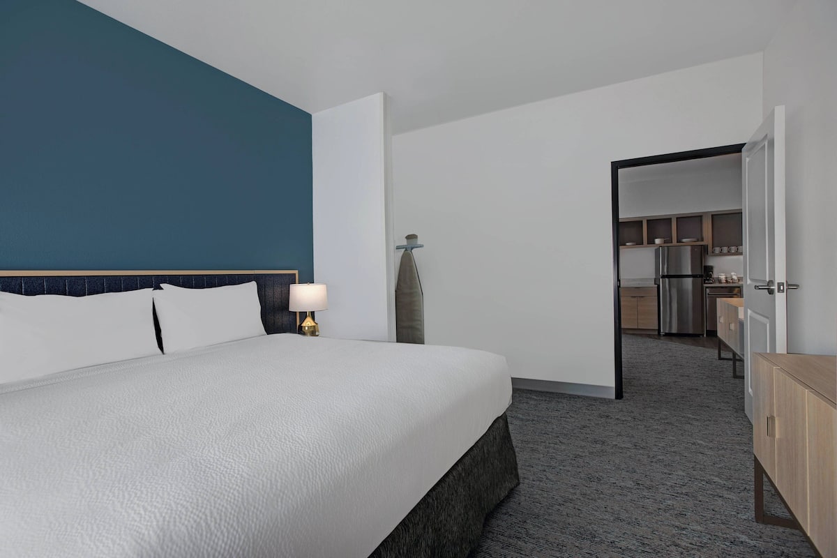 Escritorio, cortinas blackout y tabla de planchar con plancha