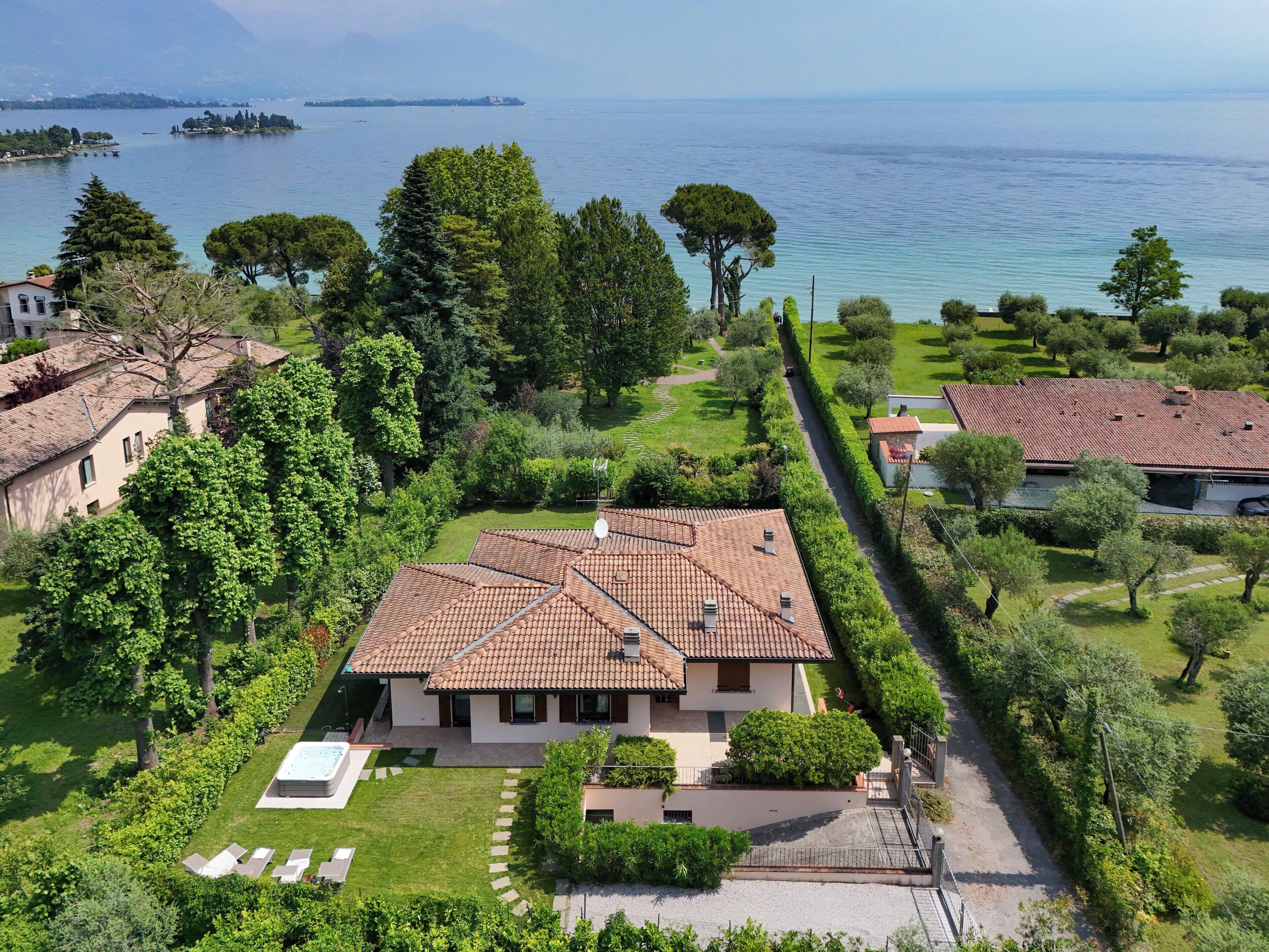A Mediterranean-style villa with a tiled roof, surrounded by lush greenery and a private pool.