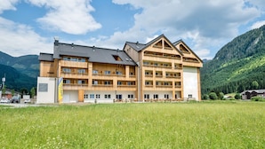 Un edificio in legno a più piani con balconi, con montagne sullo sfondo.