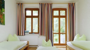 A room with two beds, a radiator, and two windows with striped curtains. - Flat in Furstenwald Near Berlin Forest (Fürstenwalde/Spree)