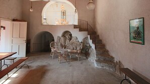 A rustic interior with a stone staircase, wooden furniture, and a ceiling fan. - Mansion in Capo Vaticano by the Sea (Ricadi)