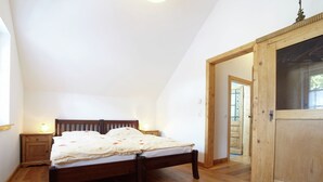 A bedroom with a wooden bed, a nightstand with a lamp, and a wardrobe. - Nostalgic Apartment in the Beautiful Eifel Region (Schleiden)