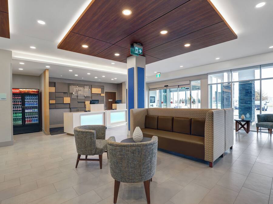 A reception area with a seating area, a Coca-Cola refrigerator, and a reception desk.