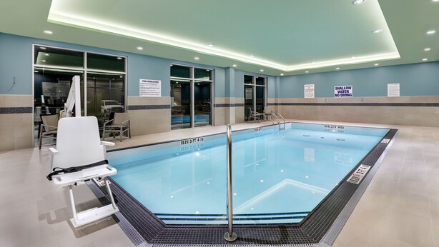 A pool area with a shallow water sign, a pool chair, and a sign indicating a shallow area. - Holiday Inn Express & Suites Port Elgin by IHG (Saugeen Shores)