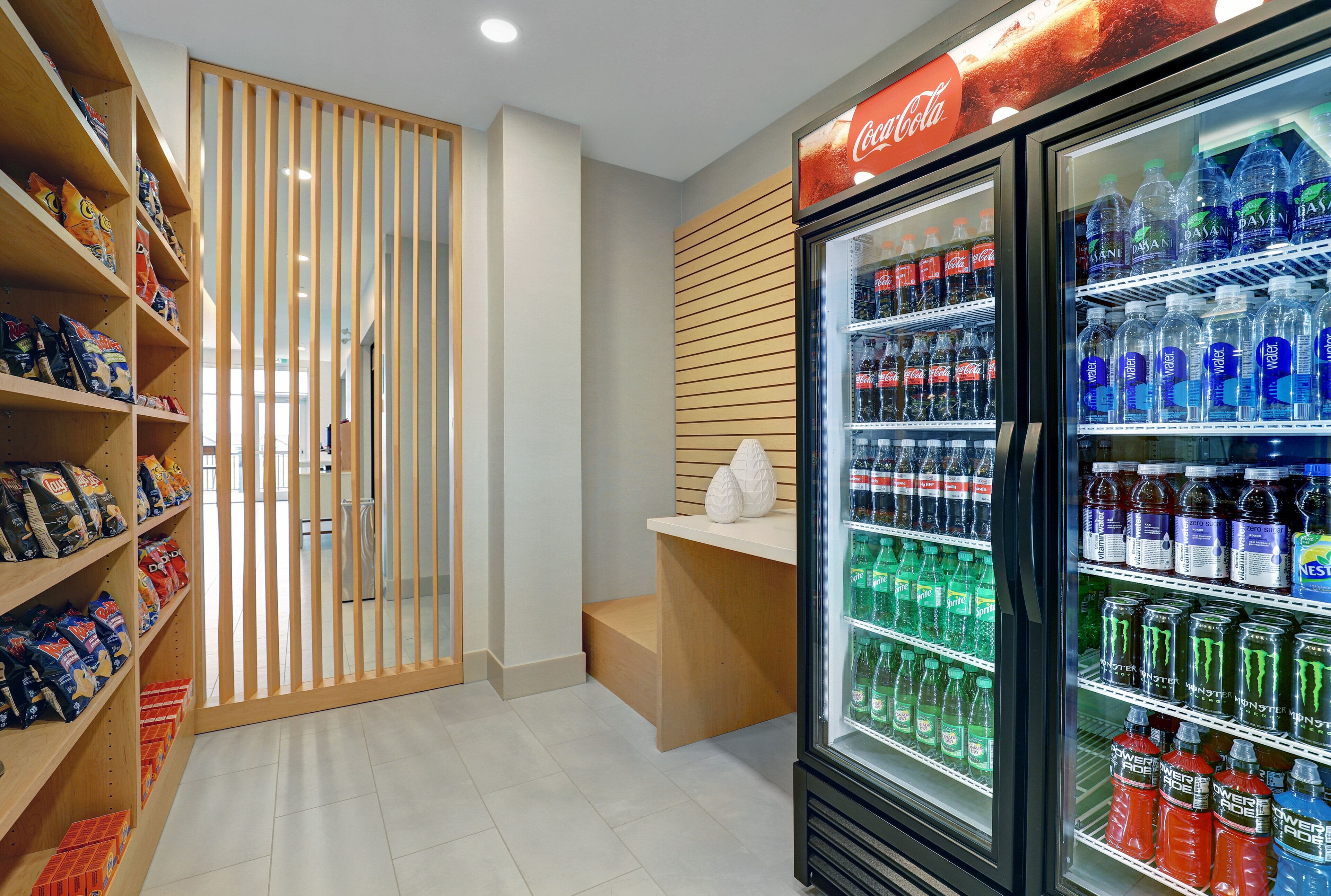 A vending machine area with snacks and beverages, including Coca-Cola and water.