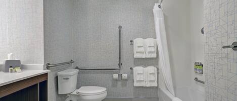 A bathroom with a toilet, a shower, and a sink.