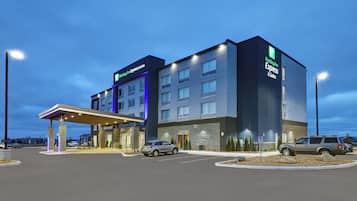 Un hotel Holiday Inn Express & Suites con entrada cubierta, varios pisos y estacionamiento.