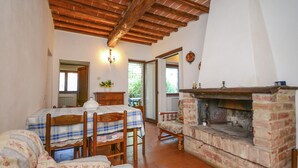 Une pièce chaleureuse avec une cheminée, une table à manger avec des chaises et un canapé.