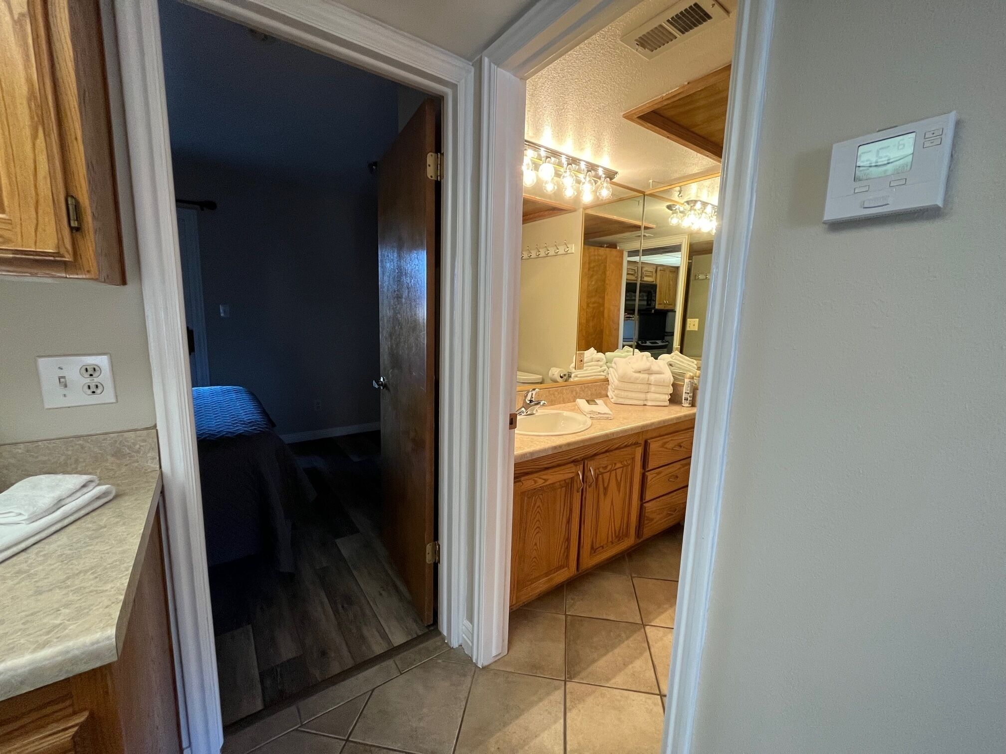 Une salle de bain avec un double lavabo, un miroir et un porte-serviettes.