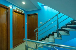A staircase with metal railings and wooden doors at the top.