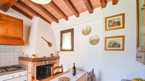 Una cocina acogedora con chimenea de ladrillo, armarios de madera y una mesa para dos.