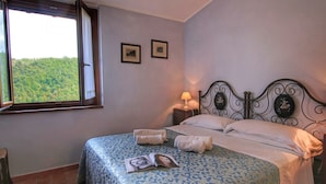 A bedroom with a bed, a nightstand, a lamp, and two framed pictures on the wall. - Pet-friendly Cottage With Pool (Bettona)