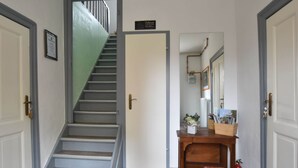 Una scala che conduce a un pianerottolo con una porta su cui è scritto 'Welcome'.