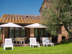 A patio area with outdoor seating and a brick building with a tiled roof. - Charming Retreat in Montaione (Montaione)