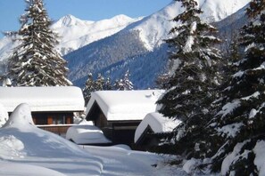 A snow-covered mountain landscape with cabins. - Family Stay in Aletsch Alps (Bellwald)