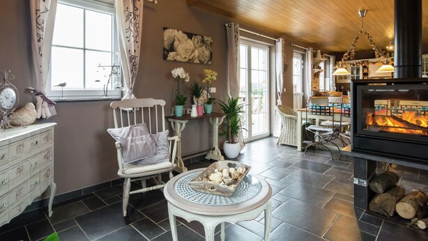 Una sala de estar acogedora con chimenea, techo de madera y un comedor con mesa y sillas.