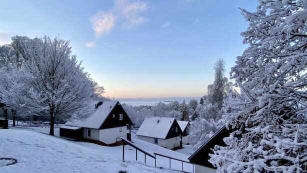 A snow-covered landscape with houses and trees.