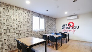 A conference room with a patterned wallpaper, a large window, and a motivational quote on the wall. - Capital O 67657 Schmear Suites (Bengaluru)