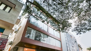 A modern building with large windows and a visible entrance. - Capital O 67657 Schmear Suites (Bengaluru)